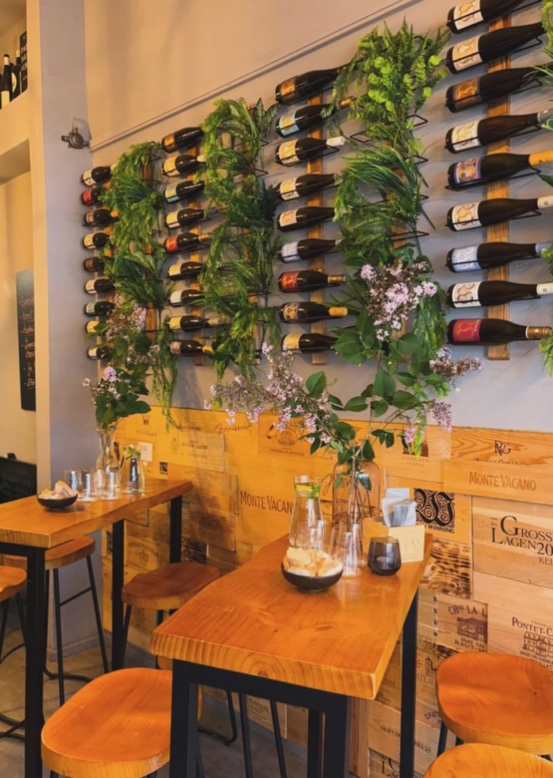 Weinwand mit Flaschen und Grün im Klein&Fein